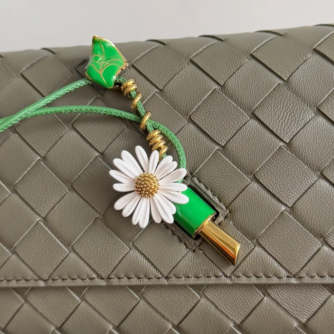 Batch 1560 Bottega Veneta2025 new product Daisy Andiamo bag, classic woven crossbody bag, thin shoulder strap is more casual, especially the small pendant design this time, daisy + green leaves + small gold chain, add a playful and smart look to the tough leather🌼Metallic button and knot closure, simple but not simple, elegant texture, elegant weaving attitude. You can also decide how to carry the bag according to your outfit and occasion. It can be used as a clutch bag, shoulder bag, or crossbody bag. It has a high usage rate. 😊Pair it with a simple skirt to instantly become relaxed and fashionable. Pair it with a smart suit to neutralize the formal feeling. It can be used for commuting and dating! Style number: 838870 (836940) Size: 19*12.6*2cm